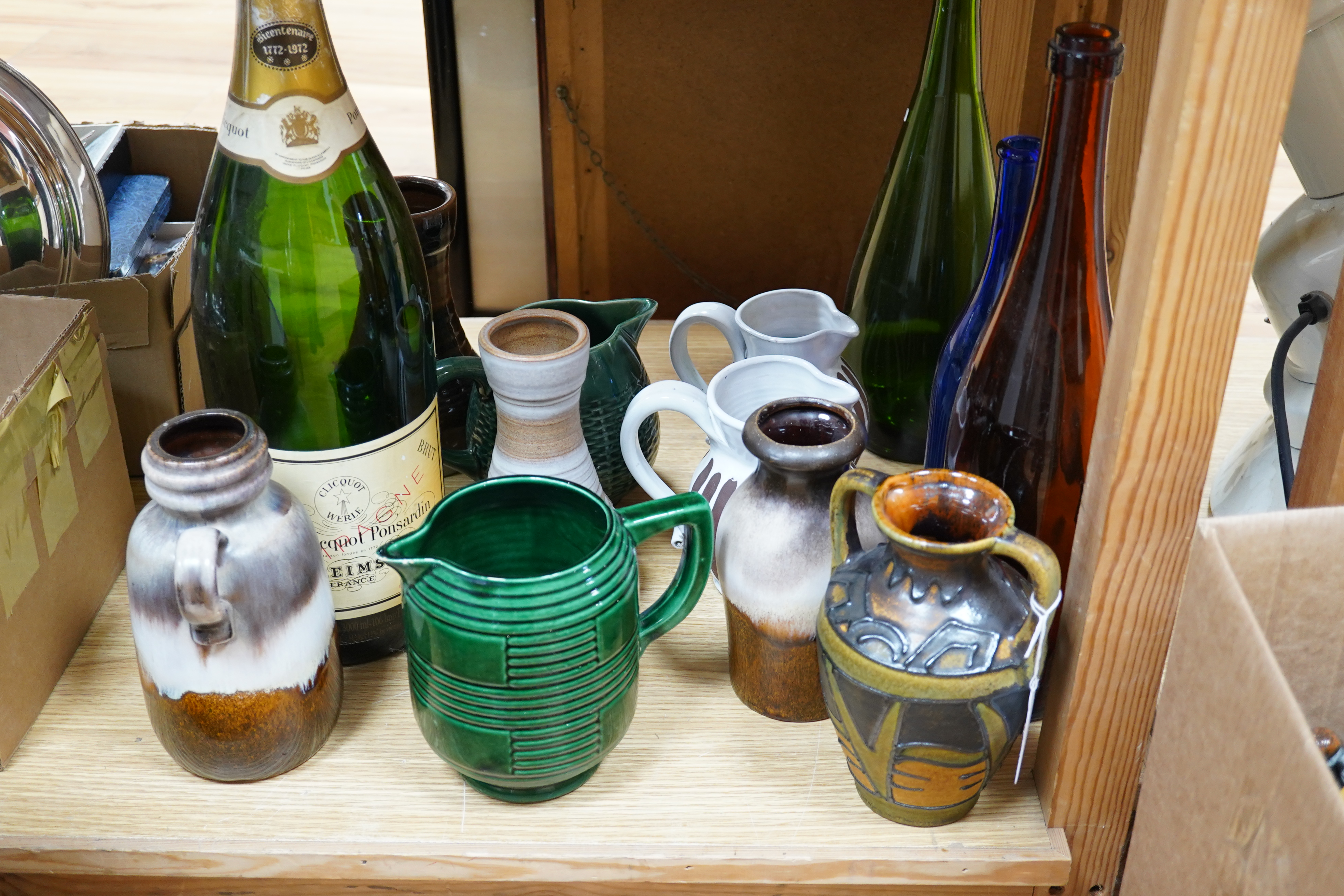 A collection of studio pottery and four glass bottles to include an oversized advertising bottle of Veuve Clicquot Ponsardin - 55cm high. Condition - fair to good